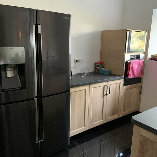 Cuisine avec portes à cadres en chêne massif avec ilot central, finition vernis naturel mat plan de travail en céramique Basalte black